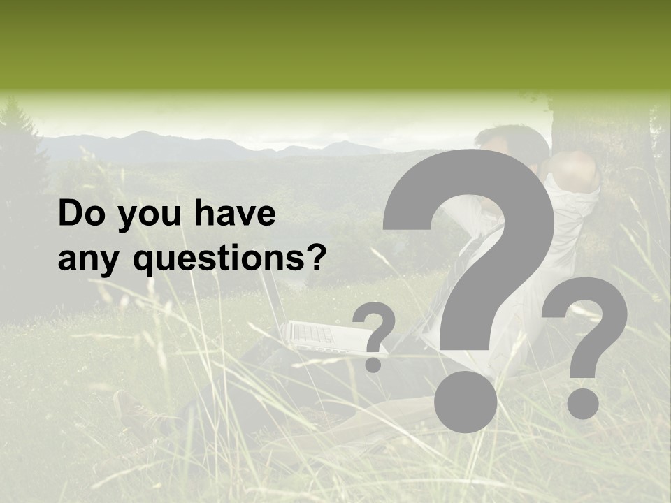 A Man Sitting In The Grass With A Laptop PowerPoint Template