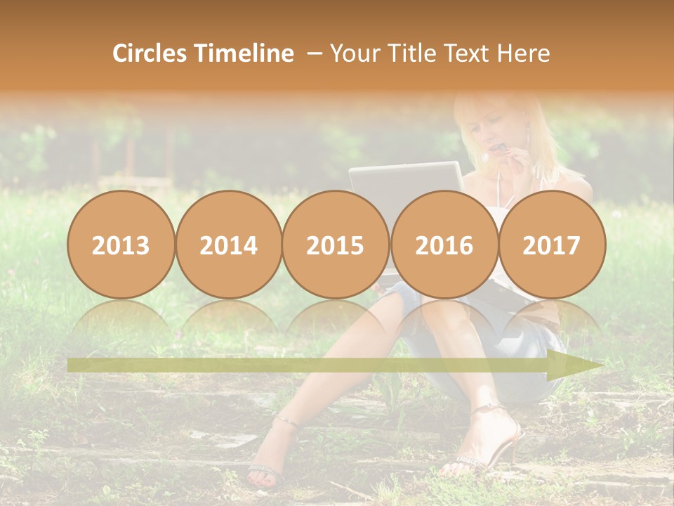 A Woman Sitting In The Grass Using A Laptop Computer PowerPoint Template