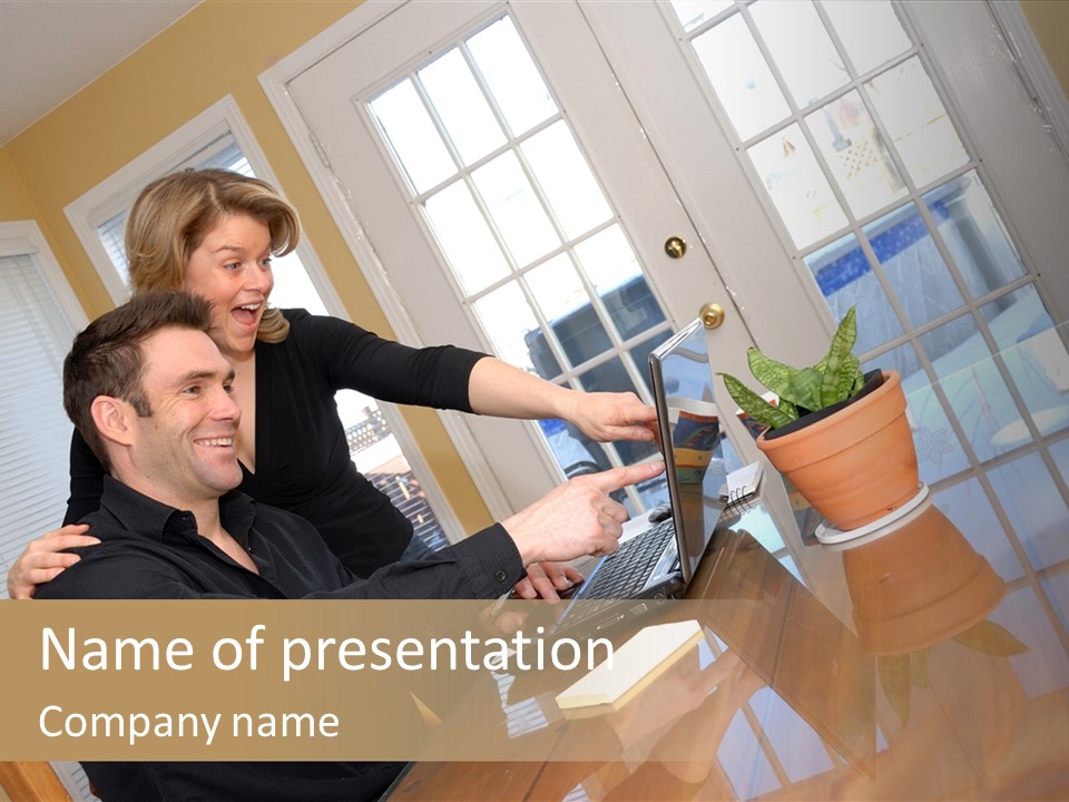 A Man And Woman Sitting At A Table With A Laptop PowerPoint Template