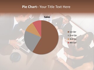 A Group Of People Sitting Around A Conference Table PowerPoint Template