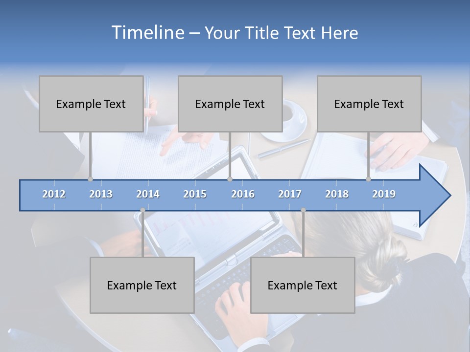 A Group Of People Sitting Around A Table Working On Laptops PowerPoint Template