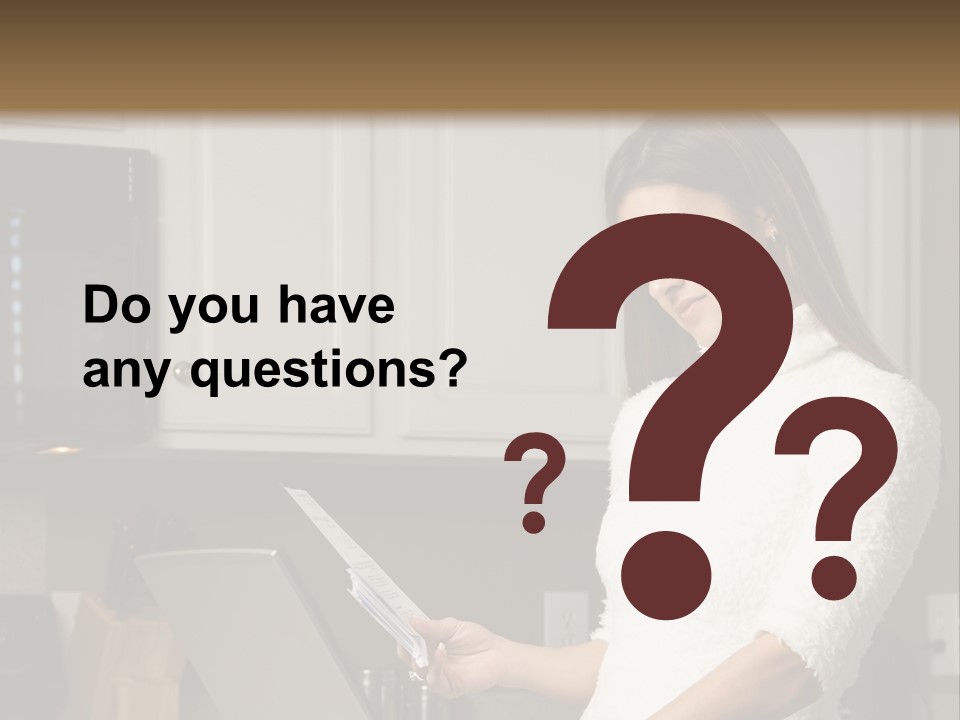 A Woman Using A Laptop Computer In A Kitchen PowerPoint Template