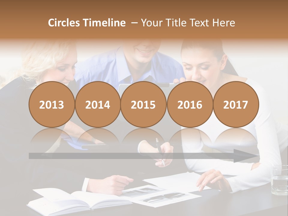 A Group Of People Sitting Around A Table With A Laptop PowerPoint Template