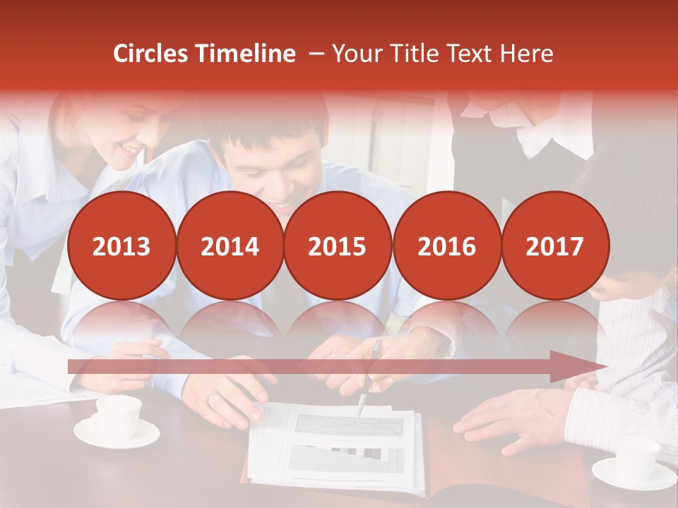 A Group Of People Sitting Around A Table Working On A Piece Of Paper PowerPoint Template