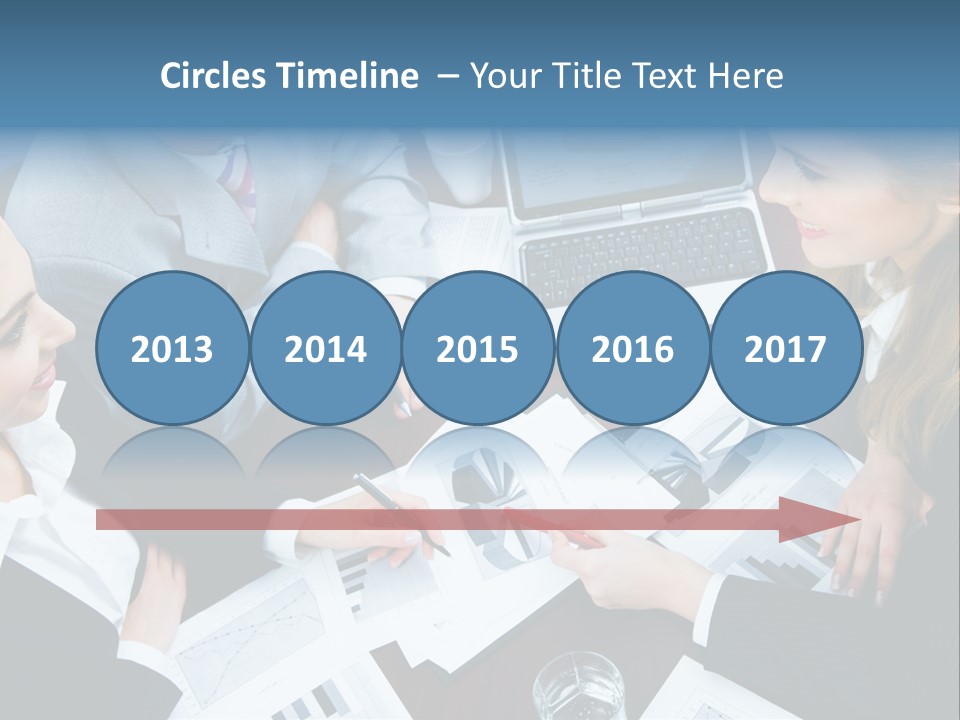 A Group Of People Sitting Around A Wooden Table PowerPoint Template