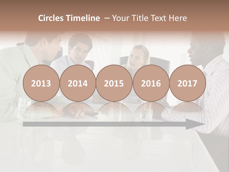 A Group Of People Sitting Around A Conference Table PowerPoint Template