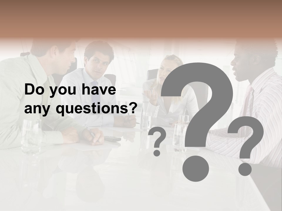 A Group Of People Sitting Around A Conference Table PowerPoint Template