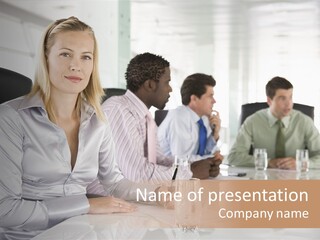 A Group Of People Sitting Around A Conference Table PowerPoint Template