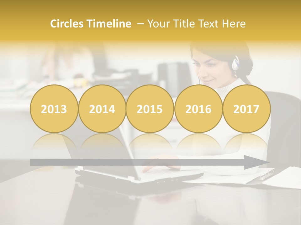 A Woman Sitting At A Desk Using A Laptop Computer PowerPoint Template