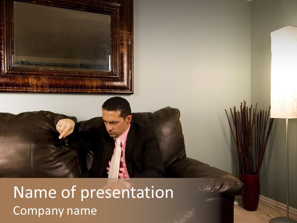 A Man Sitting On A Couch In A Living Room PowerPoint Template