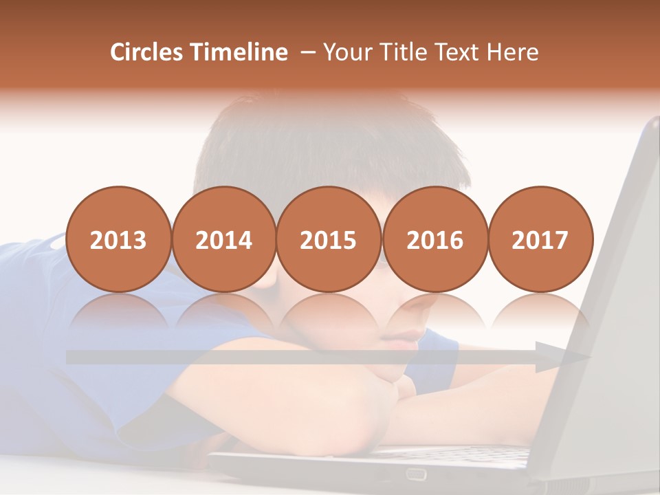 A Young Boy Laying On His Stomach Using A Laptop PowerPoint Template