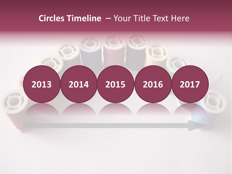 A Group Of Spools Of Thread On A White Surface PowerPoint Template