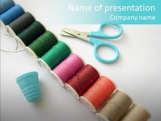 A Pair Of Scissors And Spools Of Thread On A Table PowerPoint Template