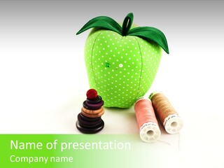 A Green Apple Sitting Next To Two Spools Of Thread PowerPoint Template