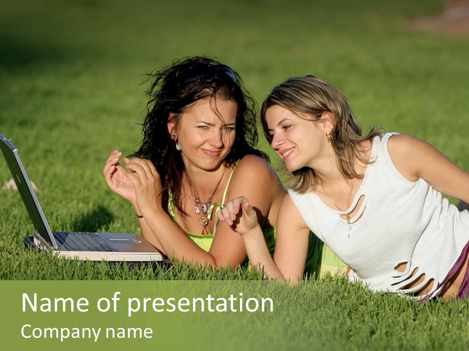 Two Women Laying In The Grass With A Laptop PowerPoint Template