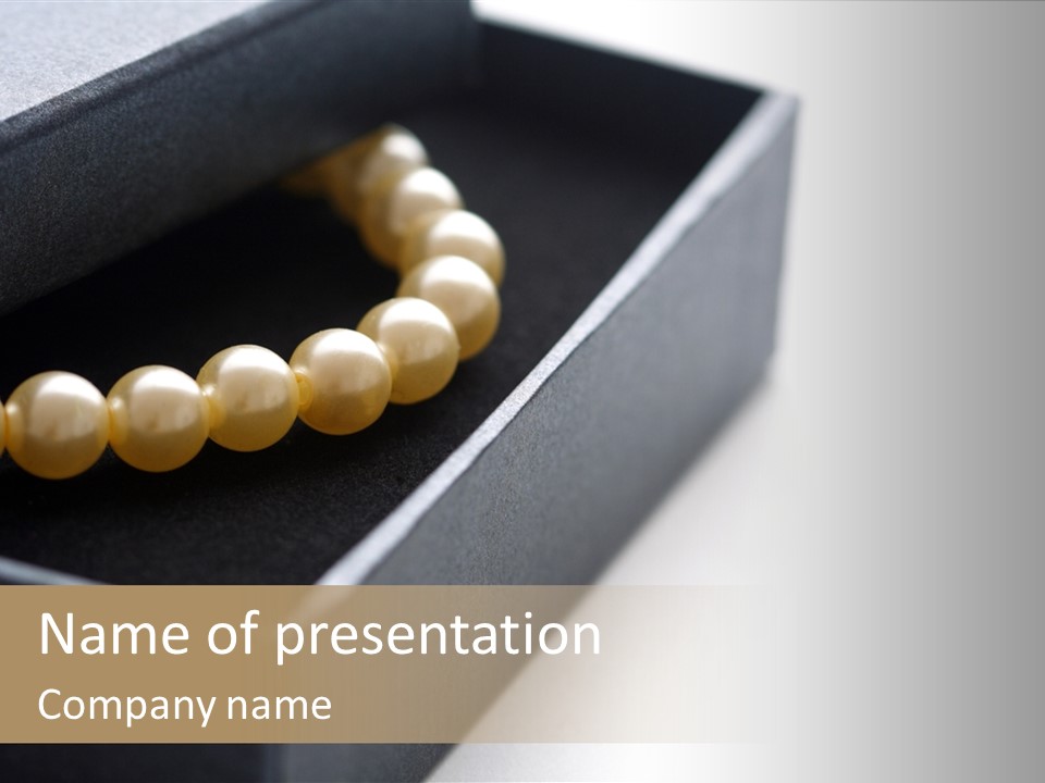 A Black Box With A Gold Beaded Necklace In It PowerPoint Template
