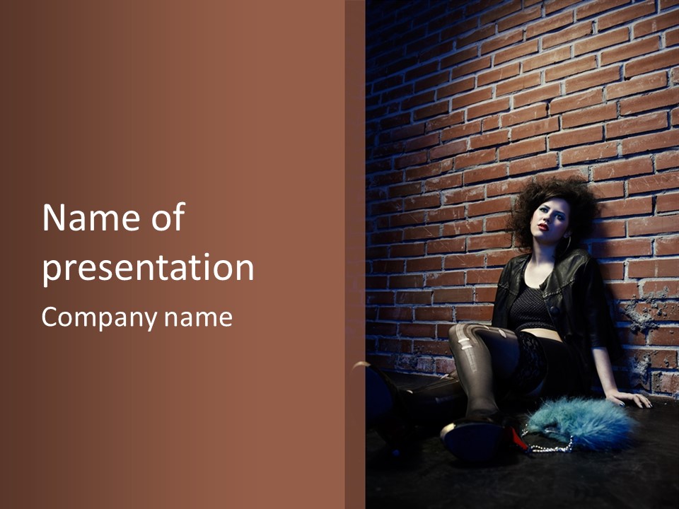 A Woman Sitting On The Ground In Front Of A Brick Wall PowerPoint Template