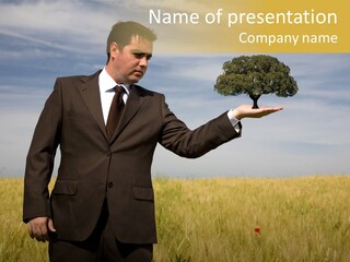 Businessman Holding A Tree In The Hand - Environment Concept - Focus On The Tree PowerPoint Template