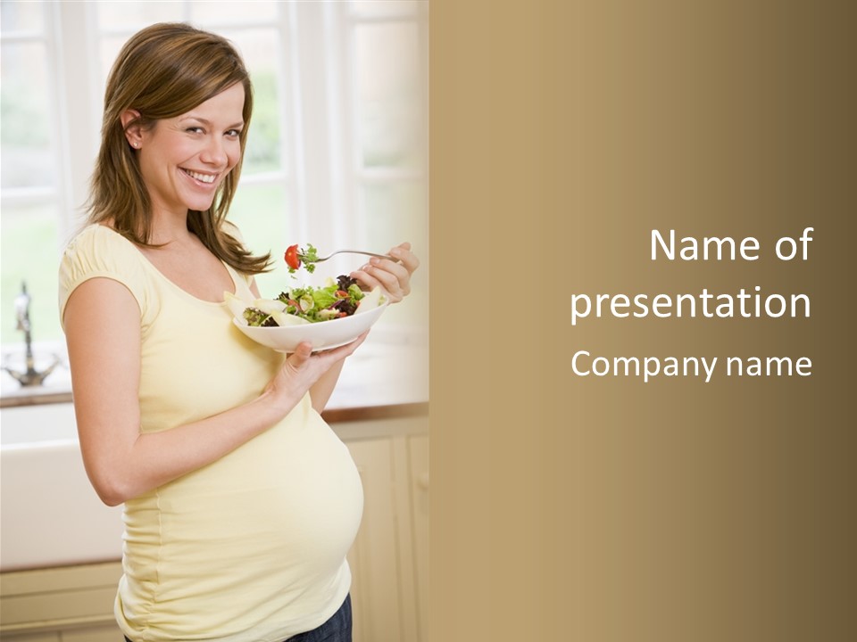 Pregnant Woman In Kitchen Eating A Salad Smiling PowerPoint Template