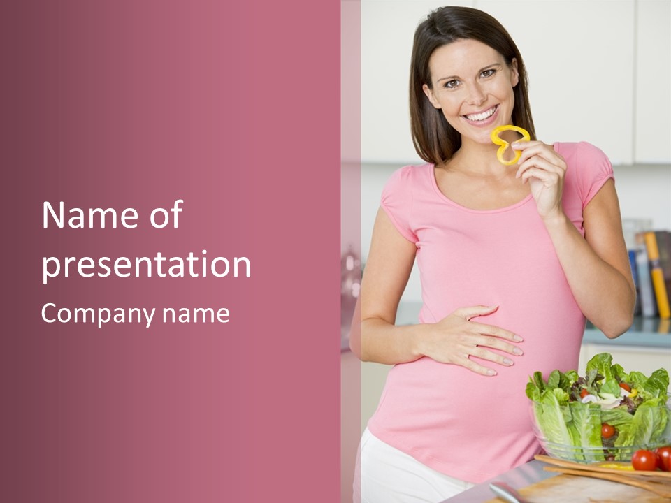 Pregnant Woman In Kitchen Making A Salad And Smiling PowerPoint Template