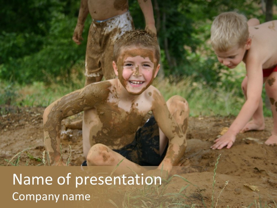 Boy Painted With Mud Sitting In Dirt Hole With Other Boys Playing In Background PowerPoint Template