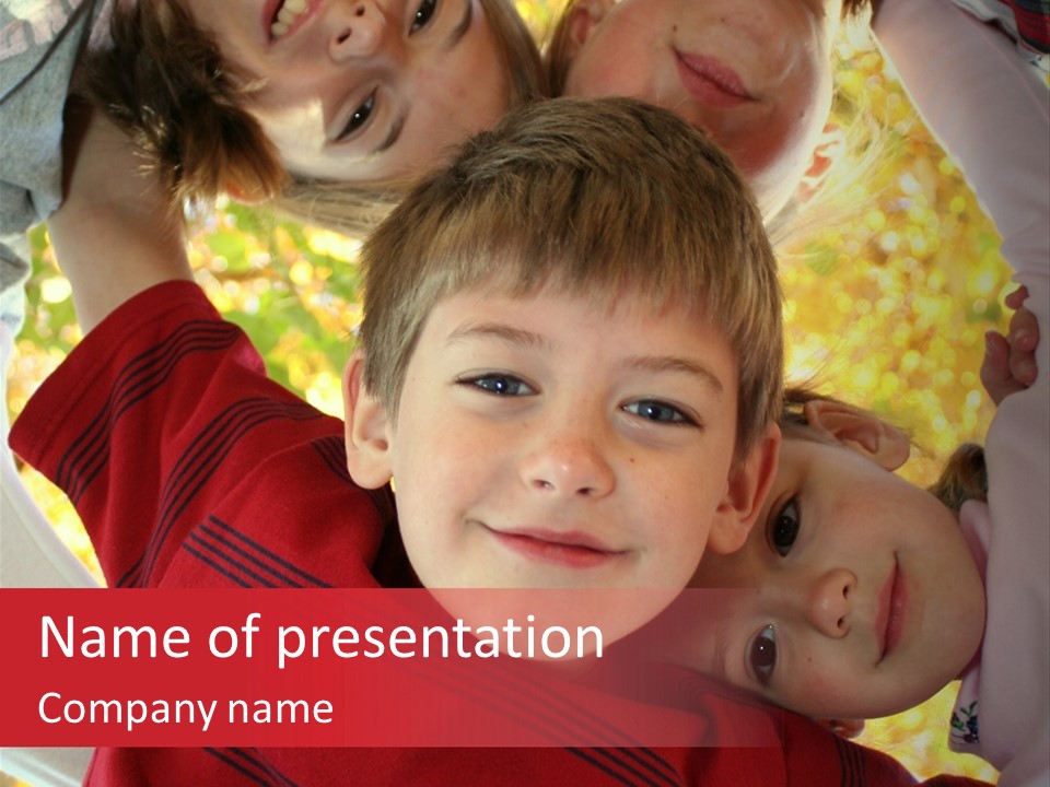 Four Smiling Children In Huddle On Autumn Day With Boy Prominent PowerPoint Template