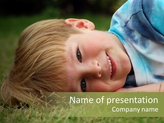 Six Year Old Boy Lying Down In The Grass. PowerPoint Template