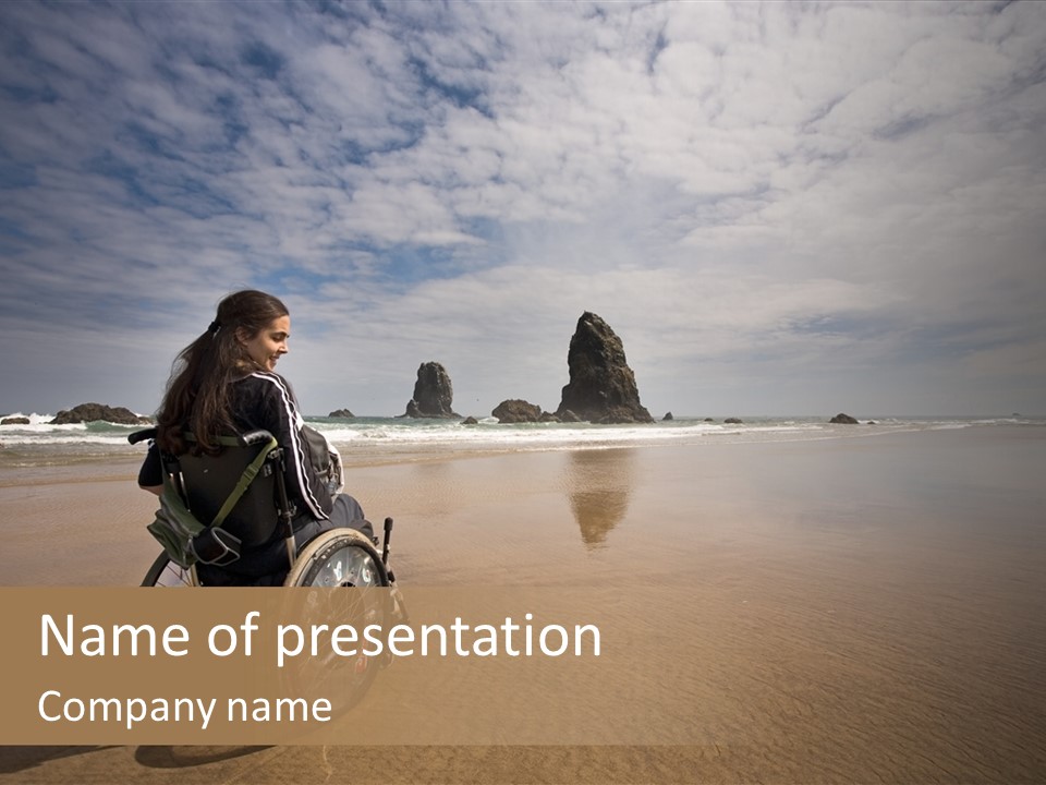 Beautiful Young Woman In A Wheel Chair Visiting Cannon Beach In Oregon, Usa. PowerPoint Template