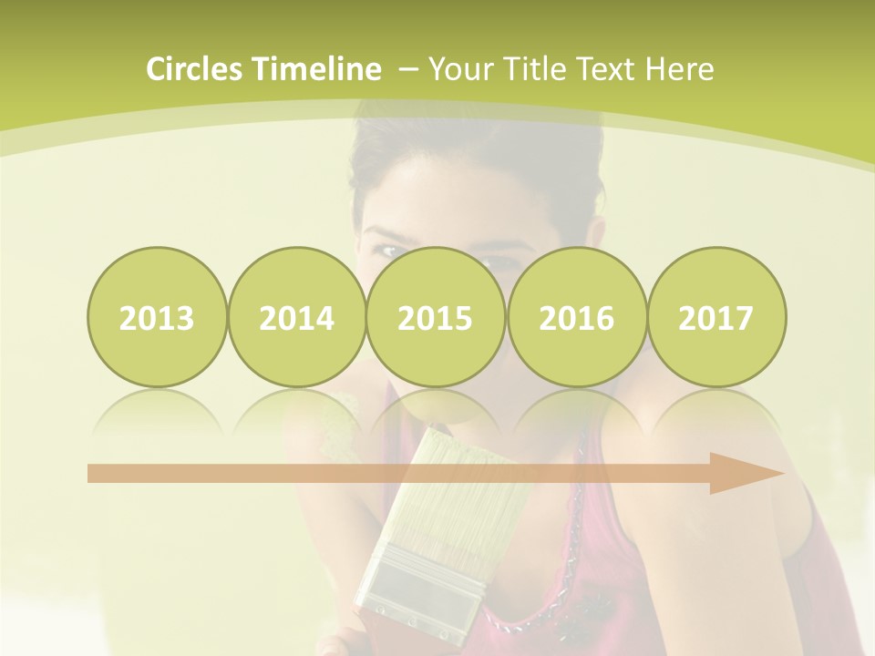 Pretty Smiling Woman Kneeling In Front Of Partially Painted Wall Holding Paintbrush. PowerPoint Template