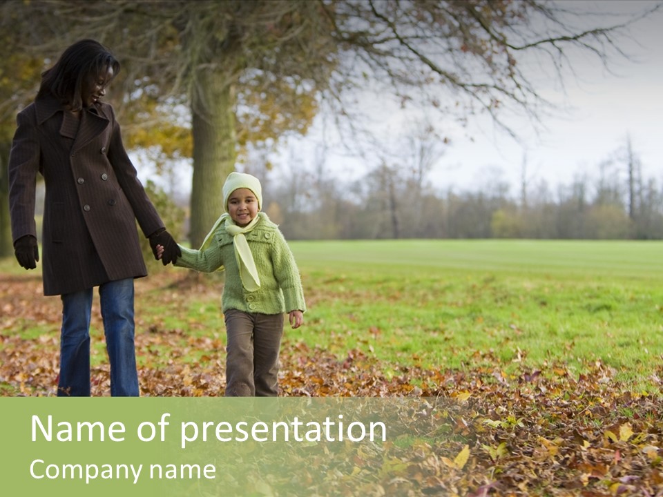 A Young Mixed Race Girl Walking Through The Autumn Leaves With Her Mother PowerPoint Template