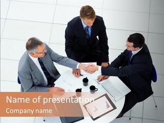 A Group Of Business People Shaking Hands Over A Table PowerPoint Template