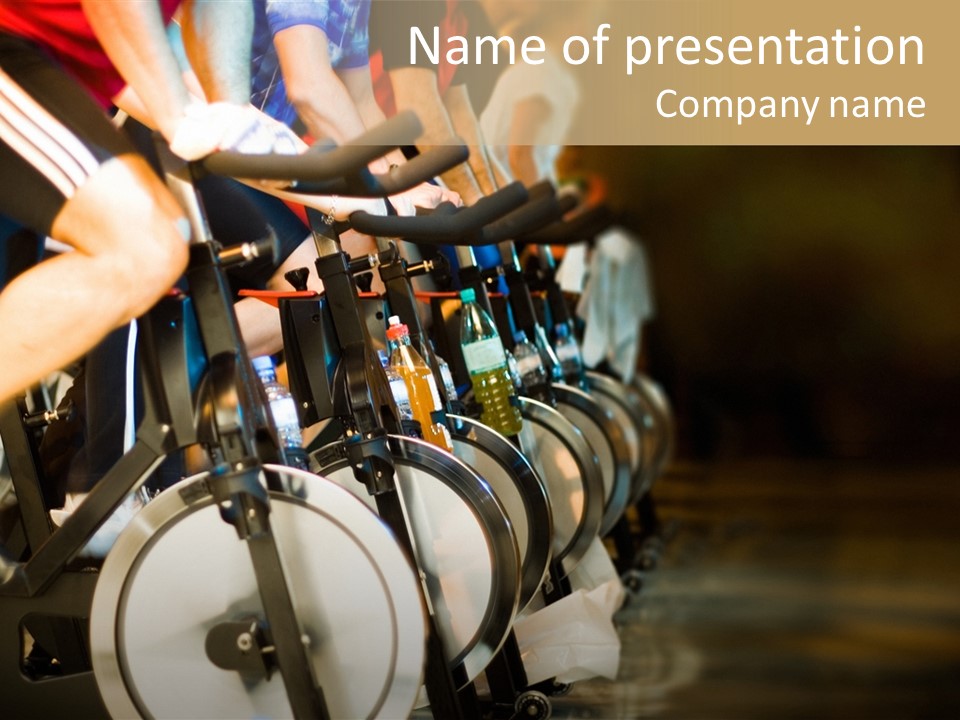 Active Lifestyle - Men & Women Pedalling On Stationery Bikes - Shallow Dof Focus On The Second Bike PowerPoint Template