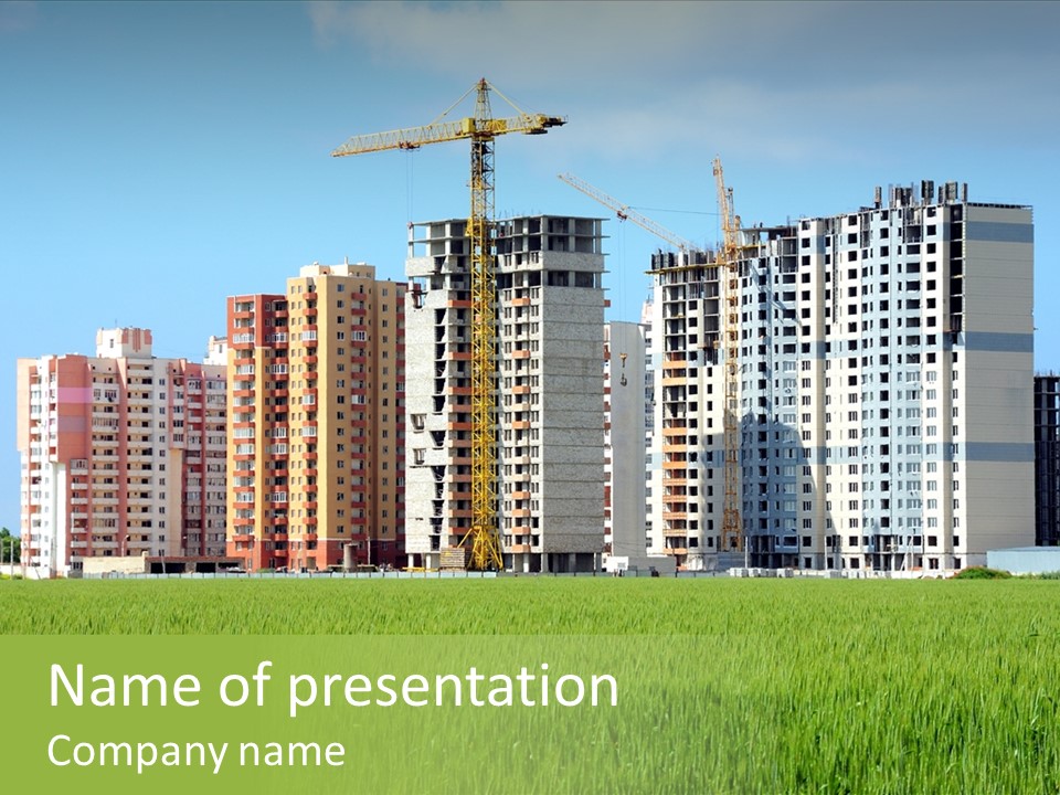 Residential Buildings, Some Of Them Under Construction, With Beautiful Green Field Foreground PowerPoint Template