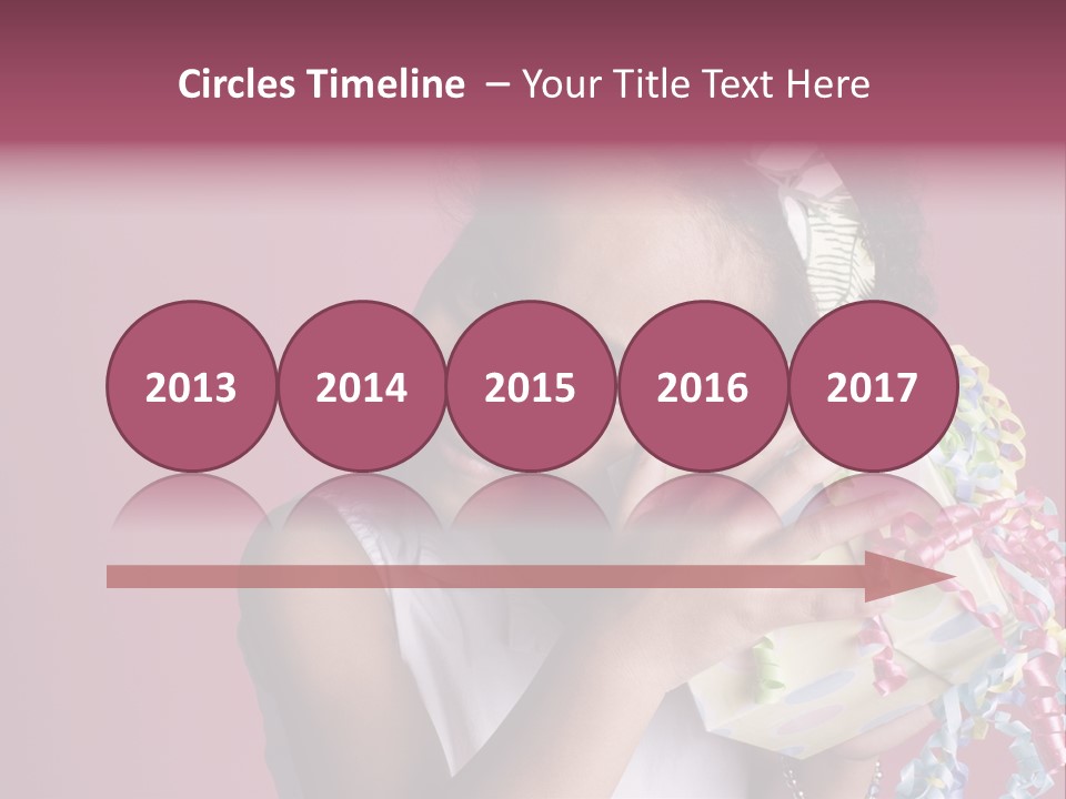 Portrait Of A Young Black Girl Sitting In A Chair Holding A Present PowerPoint Template