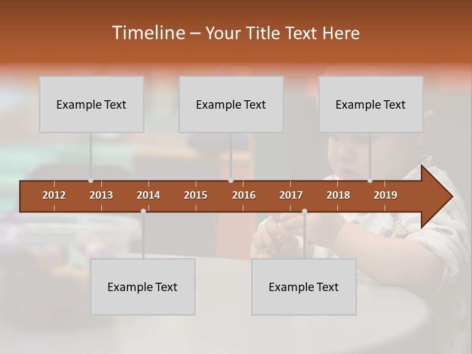 A Baby Sitting At A Table Playing With A Toy PowerPoint Template