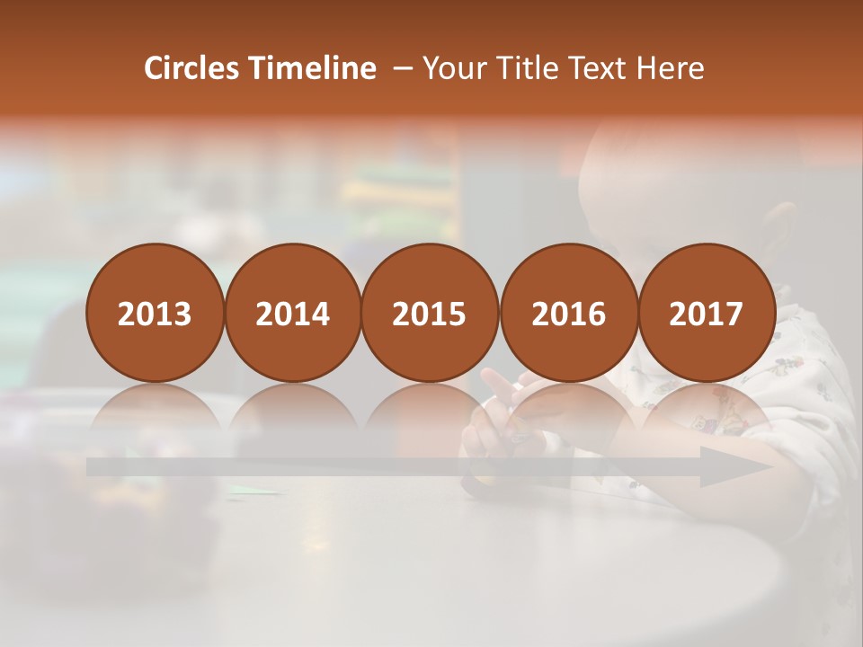 A Baby Sitting At A Table Playing With A Toy PowerPoint Template