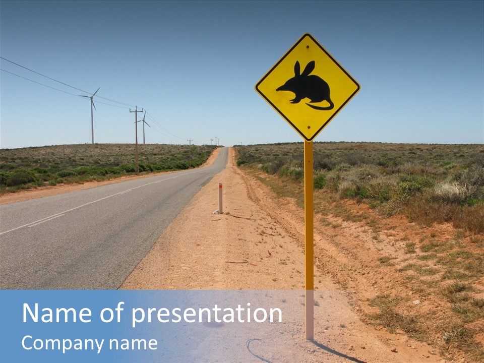 Warning Bandicoot Road Sign Standing Beside A Road In Western Australia. In Background Electric Generating Windmills. Australia PowerPoint Template