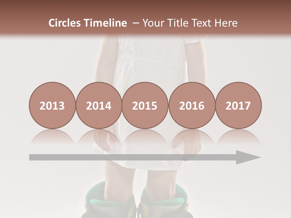 Funny Little Girl In Big Mountain Ski Boots And Short White Dress Stands On White Background PowerPoint Template