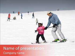 A Man Helping A Child On Skis In The Snow PowerPoint Template