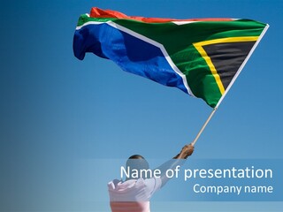 African Man Waving A South African Flag Against Blue Sky PowerPoint Template