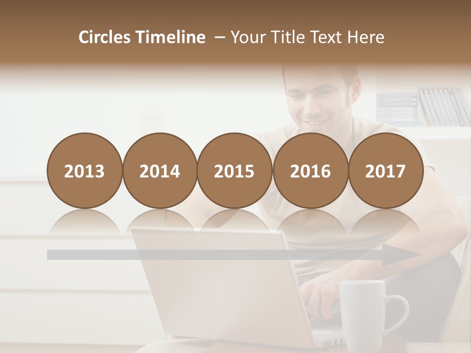 Happy Young Man In T-Shirt Sitting On Sofa At Home, Working On Laptop Computer, Smiling. PowerPoint Template