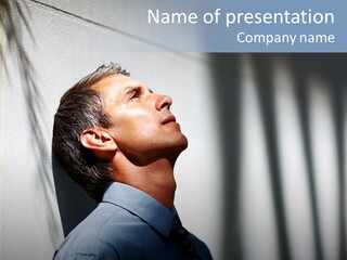 A Man In A Blue Shirt Is Looking Up PowerPoint Template