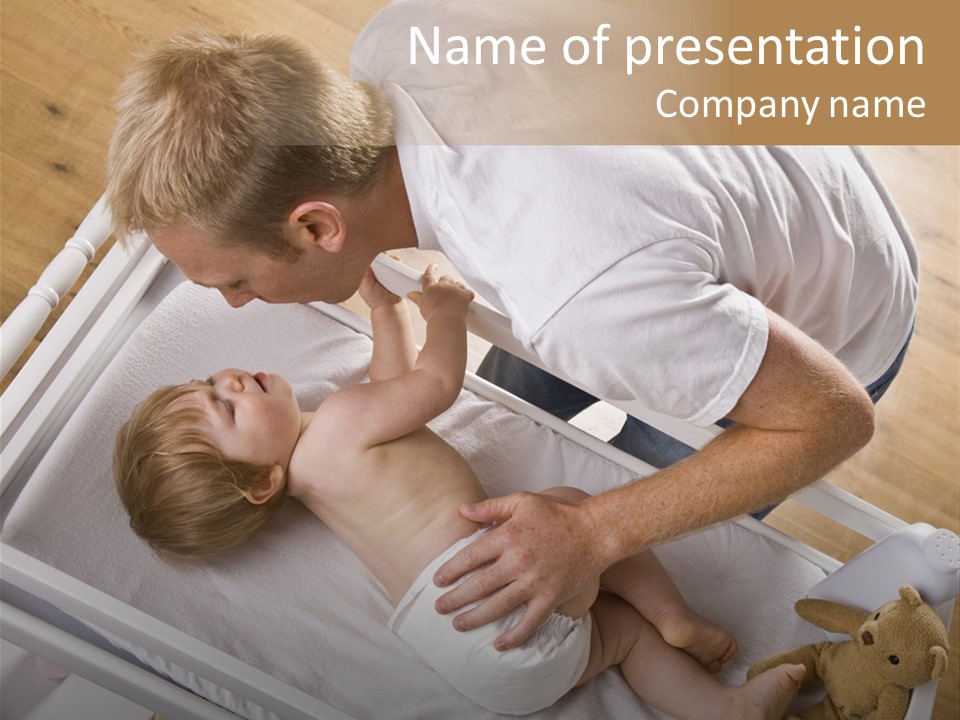 A Young Father Is Changing His Baby Daughter's Diaper. They Are Looking At Each Other. Square Framed Shot. PowerPoint Template