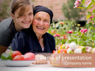 A Young Woman - Grandchild Or Carer - Next To An Old Woman At The Table, With Fresh Food In Front Of Them. PowerPoint Template