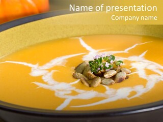 Closeup Of Bowl Of Hot Delicious Pumpkin Soup Garnished With Cream, Roasted Pumpkin Seeds And Fresh Thyme PowerPoint Template