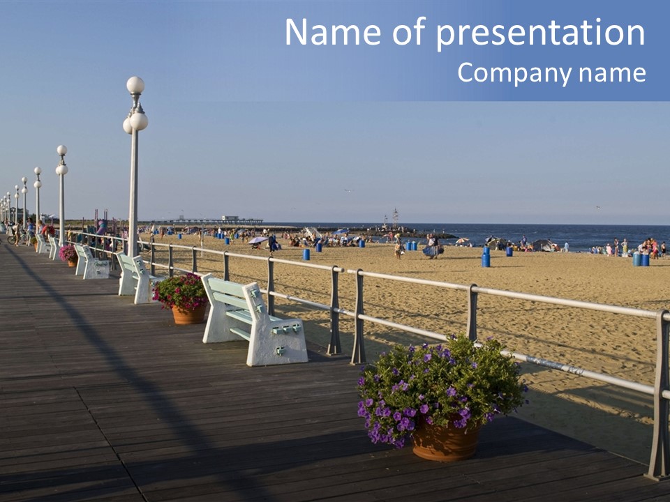 A Boardwalk With Benches And Flowers On The Beach PowerPoint Template