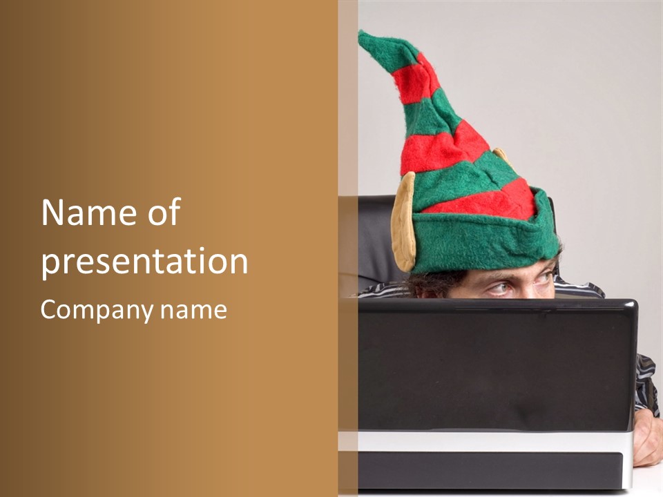 A Man Wearing A Elf Hat Sitting In Front Of A Laptop PowerPoint Template