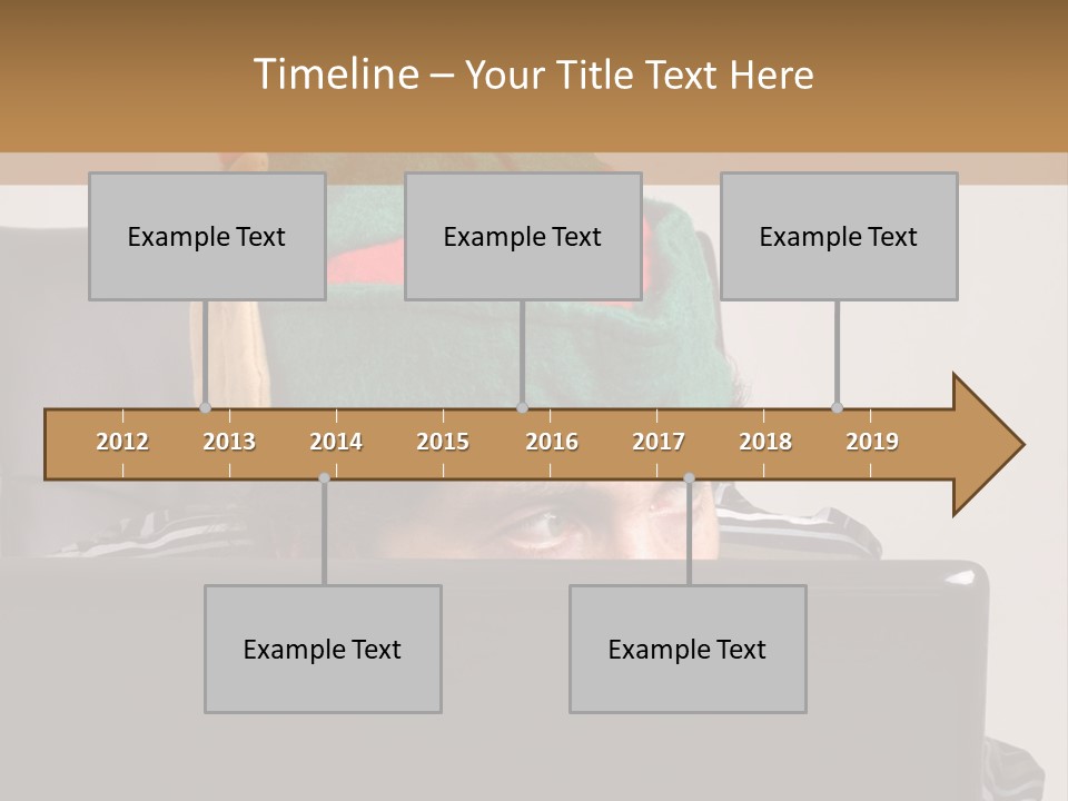 A Man Wearing A Elf Hat Sitting In Front Of A Laptop PowerPoint Template