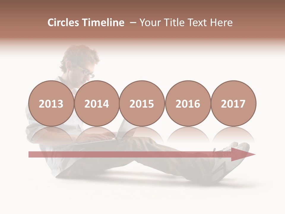 A Man Sitting On The Floor Using A Laptop Computer PowerPoint Template