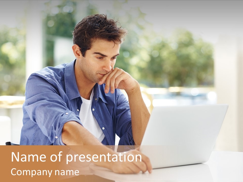 A Man Sitting In Front Of A Laptop Computer PowerPoint Template